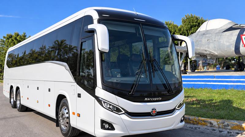 Private air-conditioned coach bus for up to 40 guests, parked in Cozumel under a clear blue sky